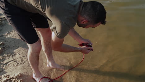 magnetic fishing man found knife in pond or lake water, pulling magnet up, closeup view