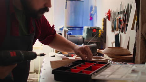 Fabricante-En-Taller-De-Montaje-Recogiendo-Tornillos-De-Caja-De-Herramientas