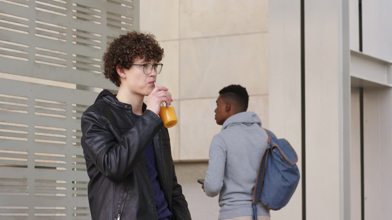 Dopo aver assaggiato un uomo dai capelli ricci che sorseggia una bevanda sul sentiero mentre un uomo con la felpa con cappuccio controlla lo smartphone, spazio per la copia