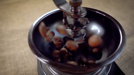 coffee beans fall in the old grinder. slow motion with rotation tracking shot.