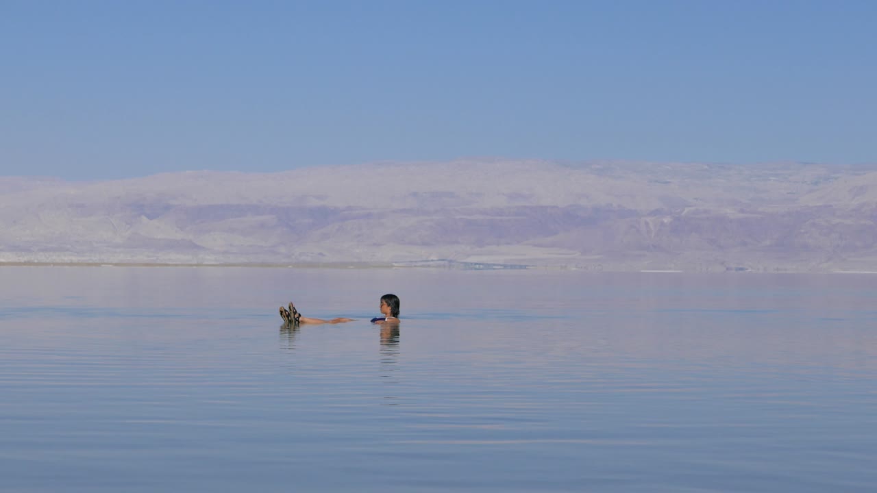 mujer asiática flotando en el mar muerto