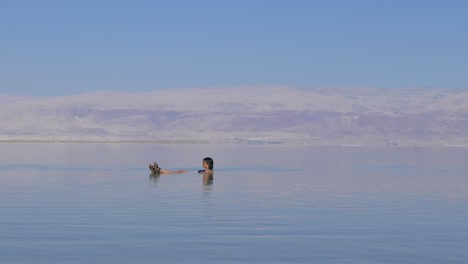 asian woman floating in the dead sea