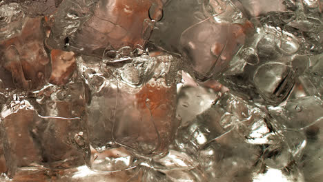 un vaso lleno de cubitos de hielo que se llena gradualmente con té helado