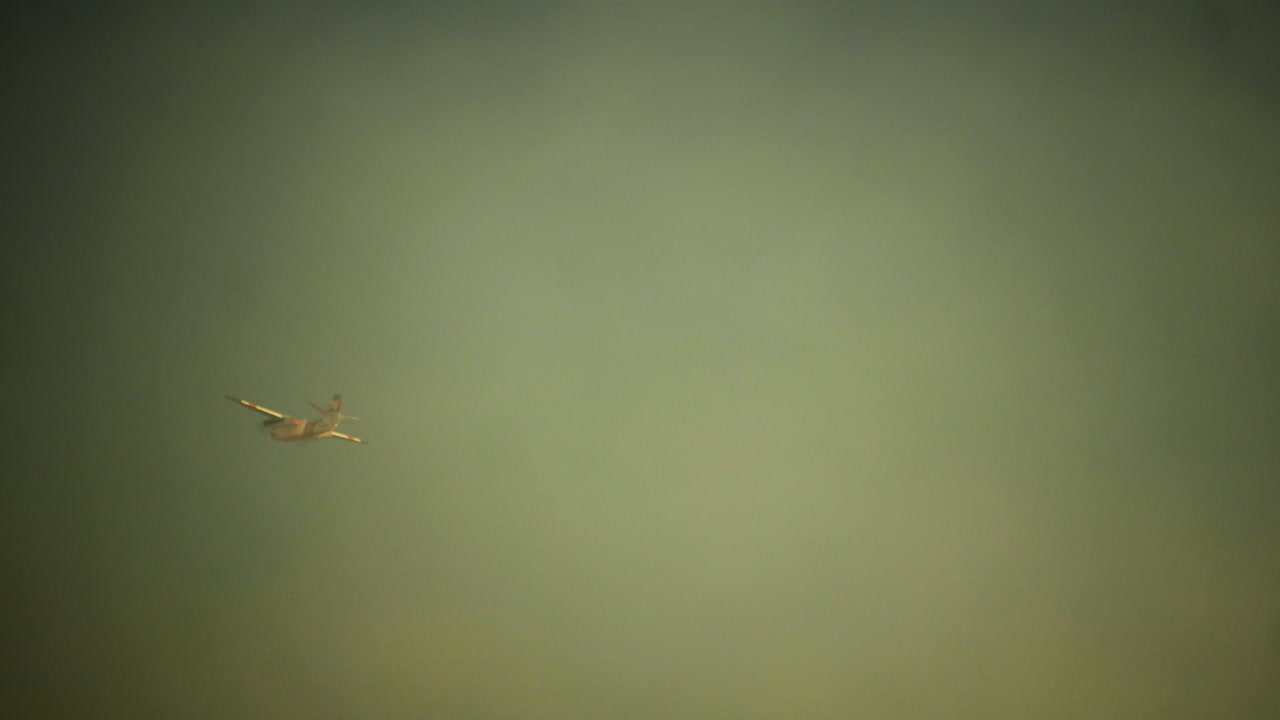 brandsläckande flygplan släpper rött brandskyddsmedel över en skogsbrand