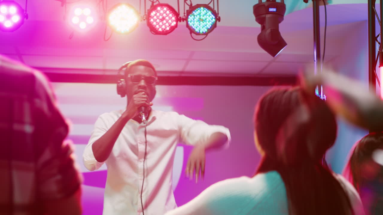 Man Performing on Stage with Lights and Crowd