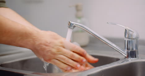 man washing hands in sink 1