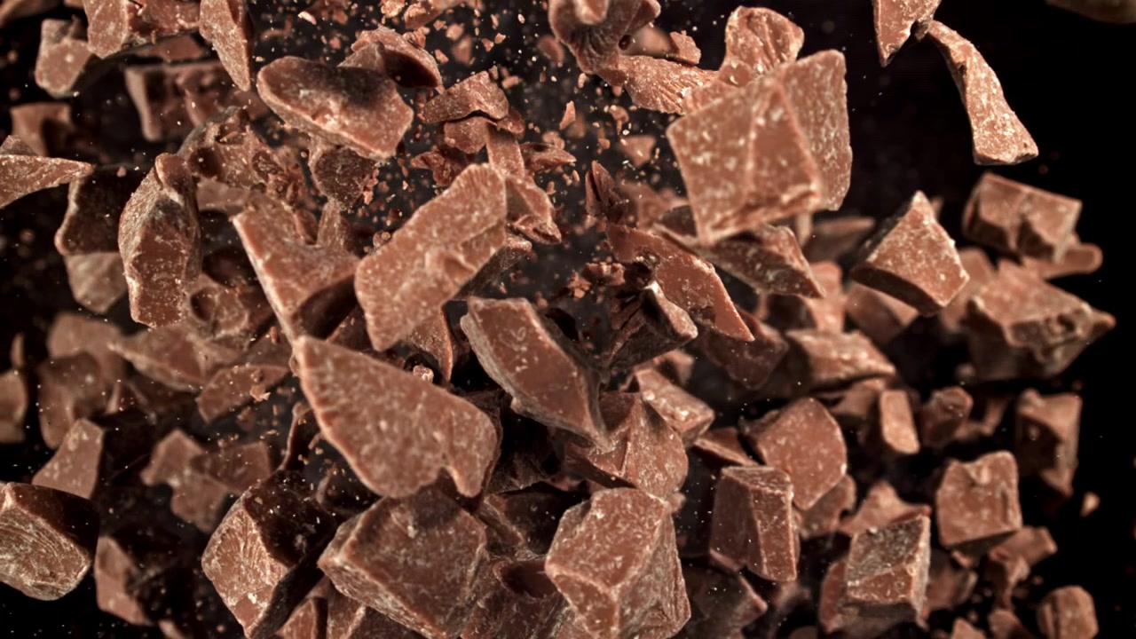 Deliziosi pezzi di cioccolato che volano in alto in super slow motion