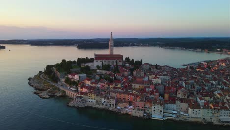 Incline-La-Toma-Aérea-Del-Panorama-De-La-Puesta-De-Sol-En-El-Casco-Antiguo-De-Rovinj,-Istria,-Croacia