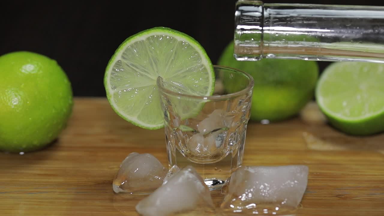 보드카 나 테킬라 를 병 에서 얼음 어리 를 넣은  글래스 에 부어 넣는다