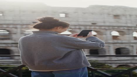 woman taking pictures of the colosseum in rome