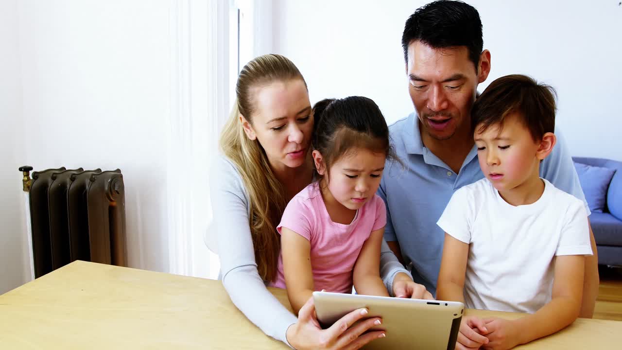 거실에서 디지털 태블릿을 사용하는 행복한 가족