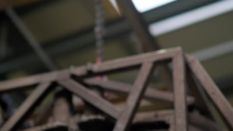 estructura de metal pesado moviéndose en el aire, sala industrial interior con cadenas y maquinaria de elevación