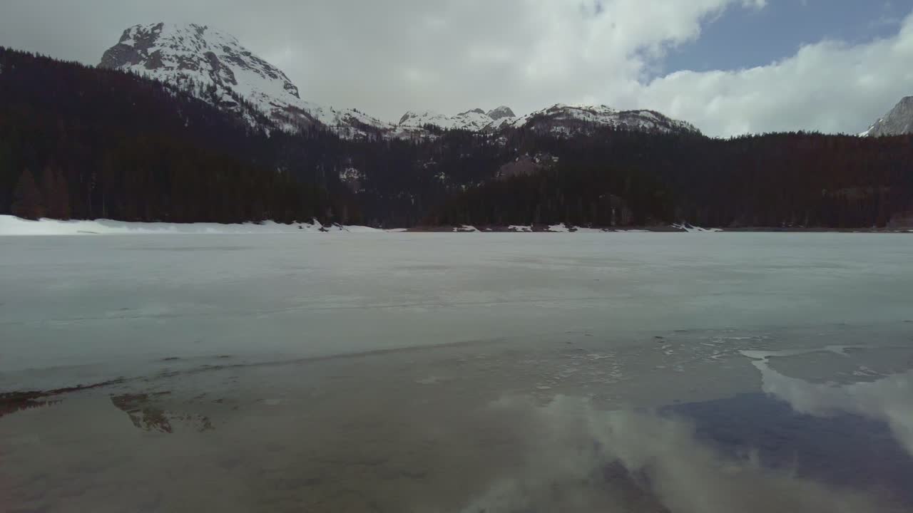 tomas panorámicas del lago negro crno jezero con montañas nevadas de durmitor en el fondo, albania