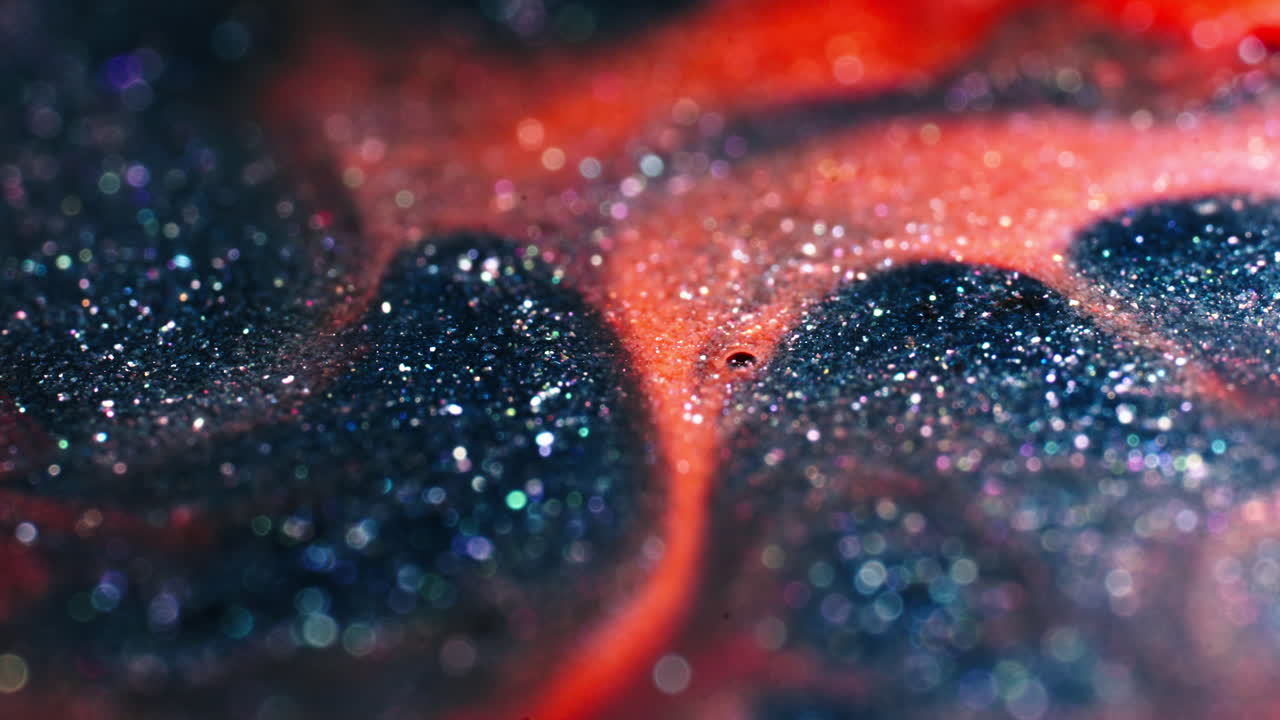 Close-up of two liquids mixing and creating abstract patterns of bubbles and swirls in motion