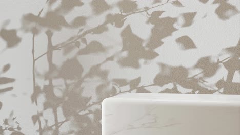 white marble pedestal with shadow of branches on a white background