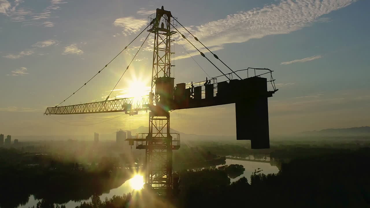 trabajo de construcción en la torre grúa máquina para construir torre alta propiedad edificio lugar de trabajo día y nubes que fluyen sobre la ciudad, las montañas en la puesta del sol