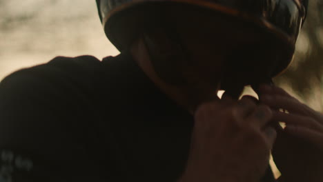 person adjusting helmet in dim light