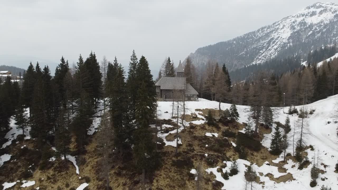 revelando el tiro de la iglesia de piedra y madera en el bosque de invierno y el camino