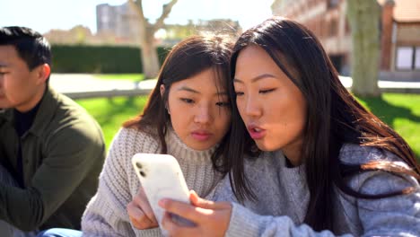 young ethnic millennials browsing smartphones and communicating in park