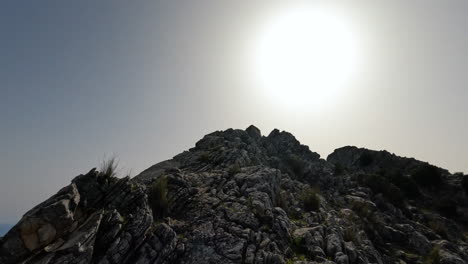 toma en movimiento de 4k de un excursionista caminando por una montaña rocosa en la concha, marbella, españa en un día soleado