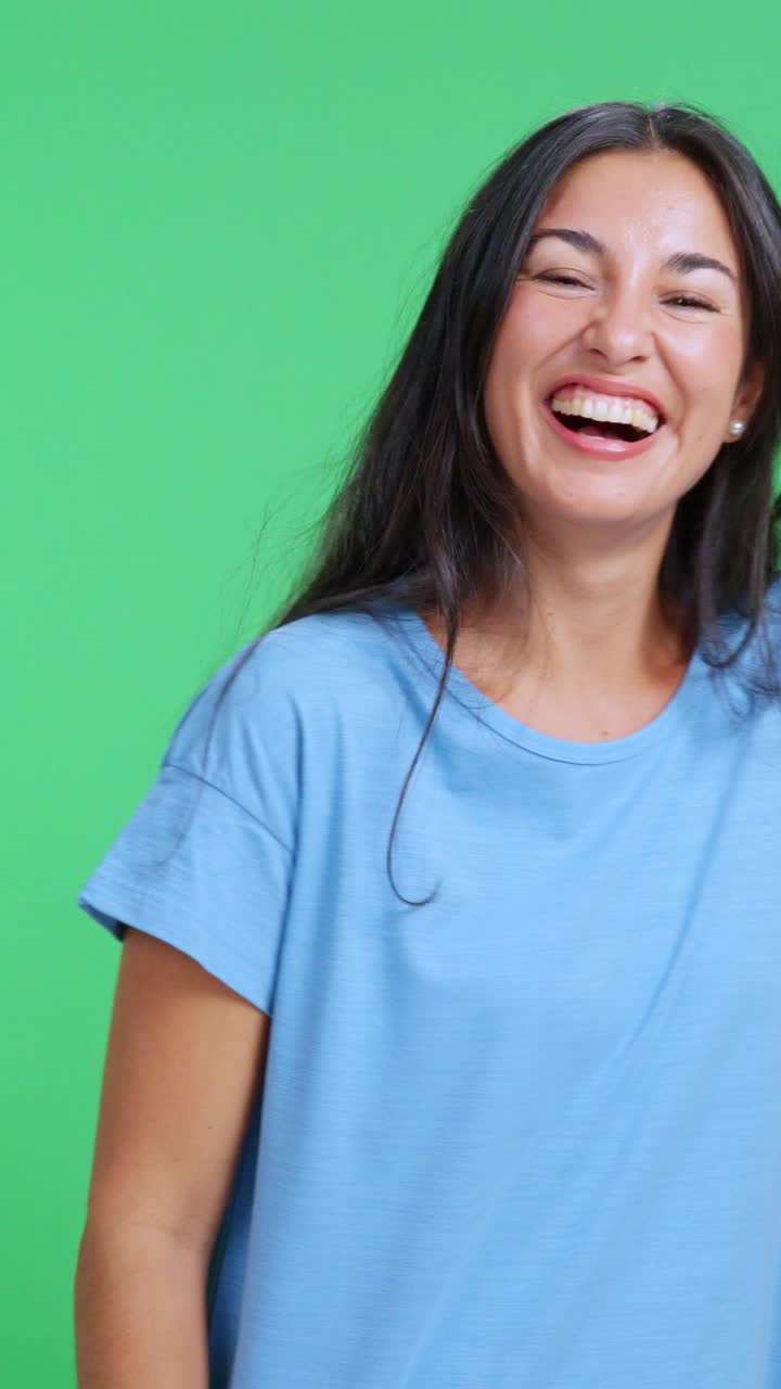 Giovane donna felice che ride su uno sfondo di green screen.