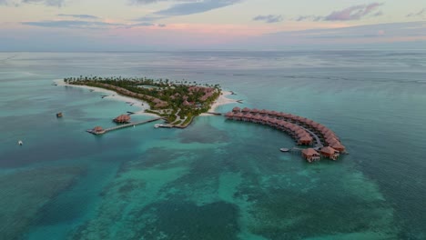 aerial view rising away from a paradise island, sunny evening in the maldives