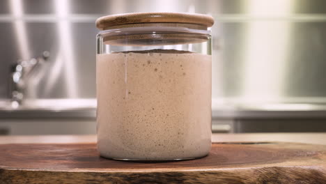 homemade sourdough starter rising in a jar during fermentation - time lapse, zoom-in