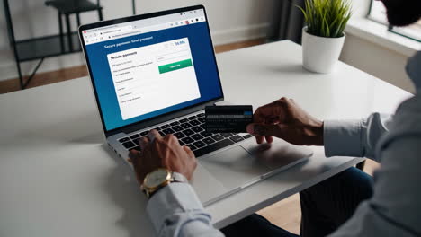 person making a secure online payment using a credit card on a laptop