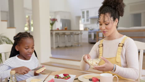 happy african american parents and daughter having breakfast at home, slow motion