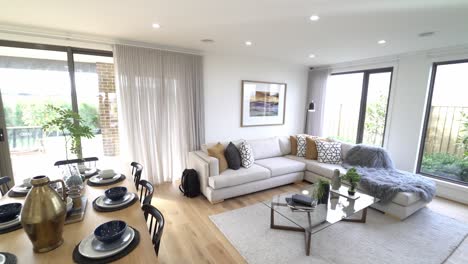 Showing-off-beautiful-bright-home-with-cream-couch-with-wooden-dining-table-and-floor-boards