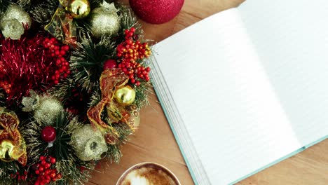 primer plano de una taza de café con decoración navideña y cuaderno