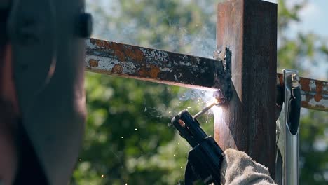 slow motion close view welder connects metal parts of fence