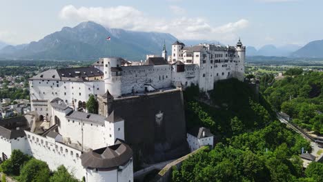 towering medieval fortress stands proud above alpine valley and rooftops