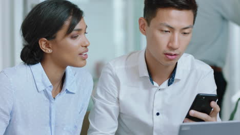 young asian busienssman intern using smartphone working with colleague showing online ideas brainstorming together in office