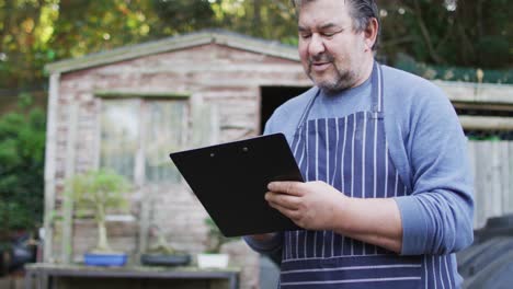 Caucasian-male-gardener-using-tablet-at-garden-center