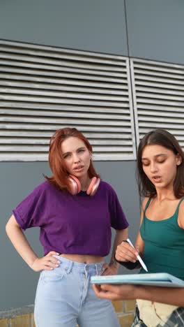 dos mujeres jóvenes estudiando al aire libre
