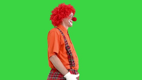 funny clown with red hair walking comically on a green screen, chroma key