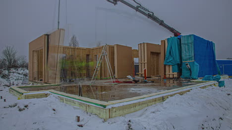 lapso de tiempo de la construcción de un edificio prefabricado ensamblado por un equipo y una grúa en invierno