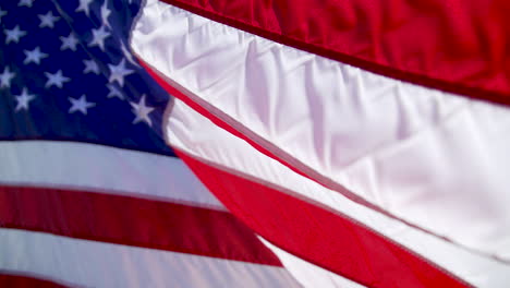 close up of a us flag waving outside in slow motion on a sunny day, with a blurred background of the dessert