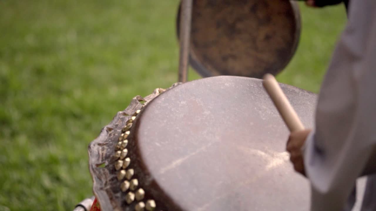 Primo piano di un tamburo suonato all'aperto con intensità ritmica.