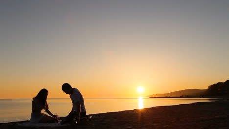 Couple drinking wine. Silhouette of young couple drinking wine on beach