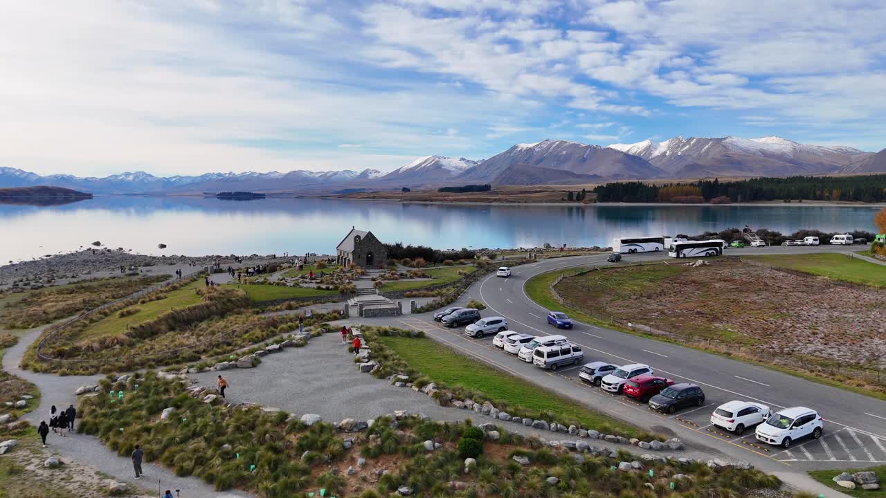 Aerial footage captures Lake Tekapo's serene waters, the Church of the Good Shepherd, and surrounding landscapes under clear skies