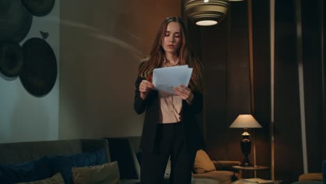 business woman looking documents in hotel lobby at evening. working late hotel