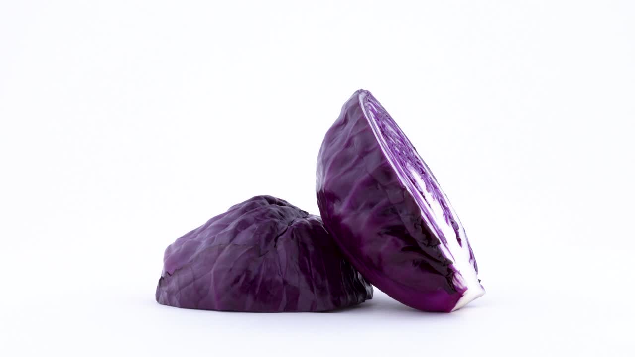 dos mitades de mini repollo púrpura. corte cruzado. girando en la mesa giratoria aislado en el fondo blanco. primer plano. macro.