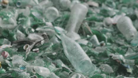 detail of green and white glass bottles abandoned on a mountain of garbage