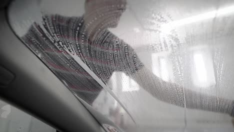 worker washing car by foam sponge