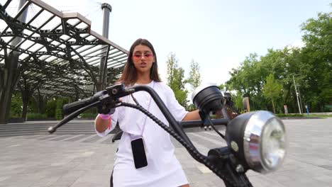 young woman riding an electric scooter in a park