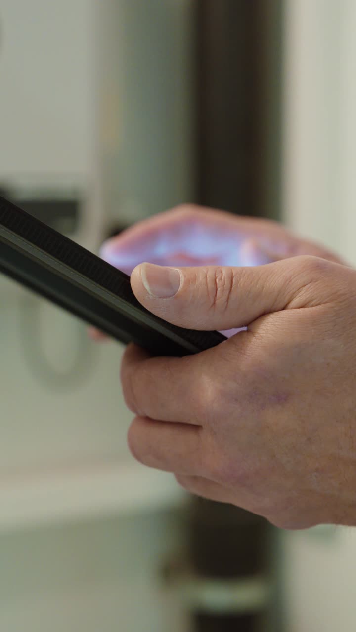 Primo piano di mani che utilizzano un touchscreen di smartphone al chiuso, illustrando la comunicazione mobile, l'interazione digitale e l'uso quotidiano della tecnologia.