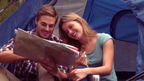 couple looking at map in their tent