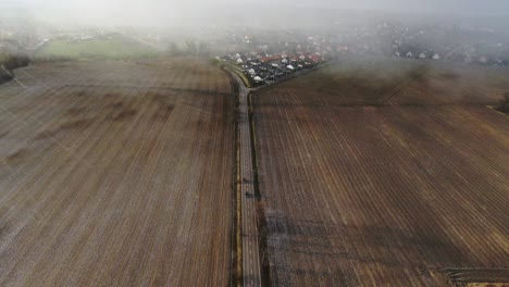 Auto-überholt-Auf-Leerer-Straße-Zwischen-Feldern-Schneesturm-Ab-Antenne